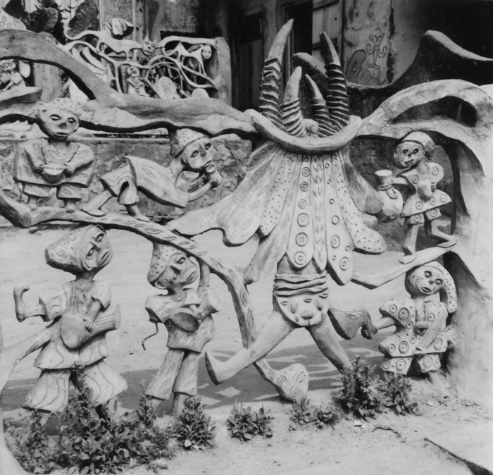 Een cementen sculptuur van Adebisi Akanji bij de ingang tot het huis van Susanne Wenger